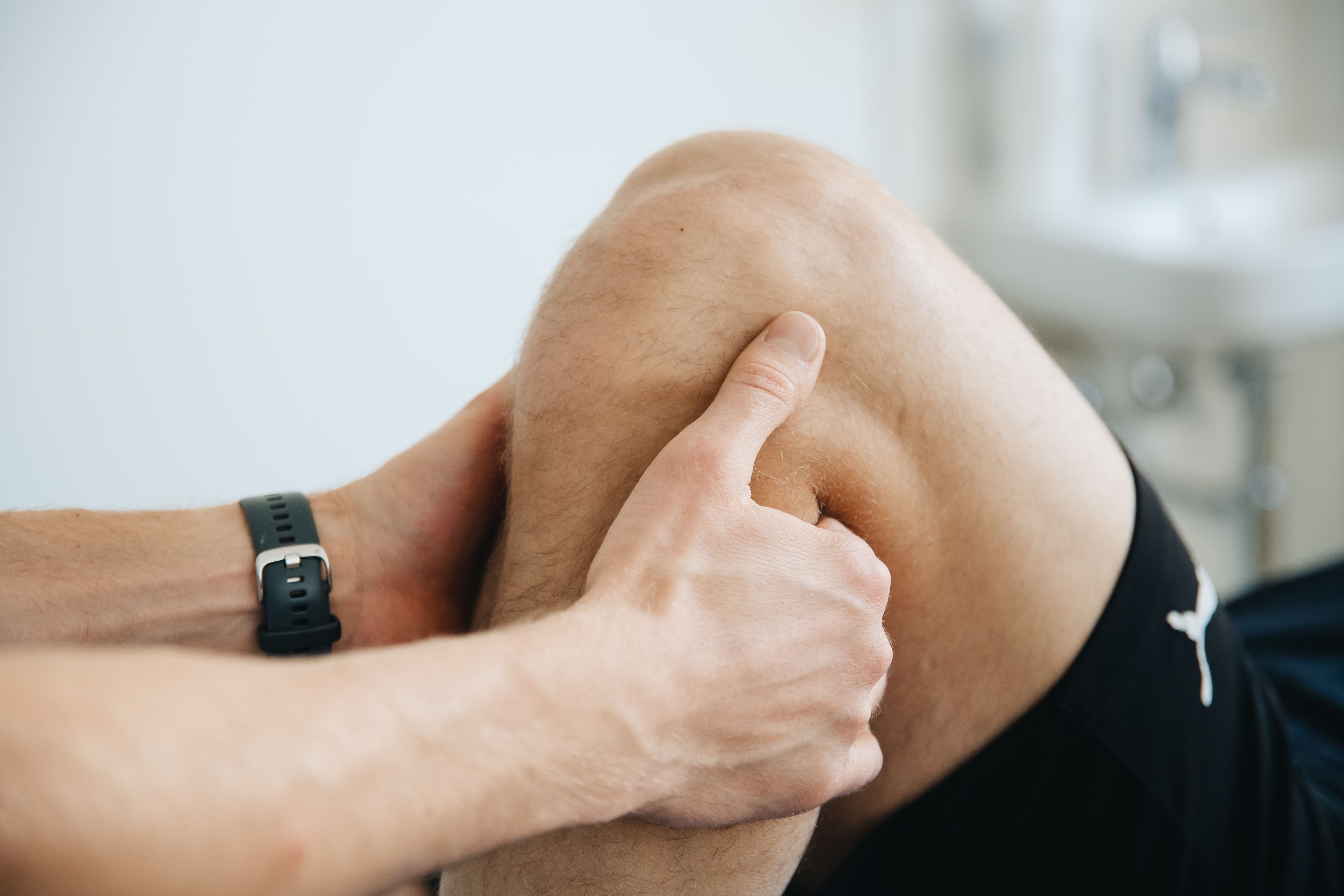Therapist performing hands-on knee assessment