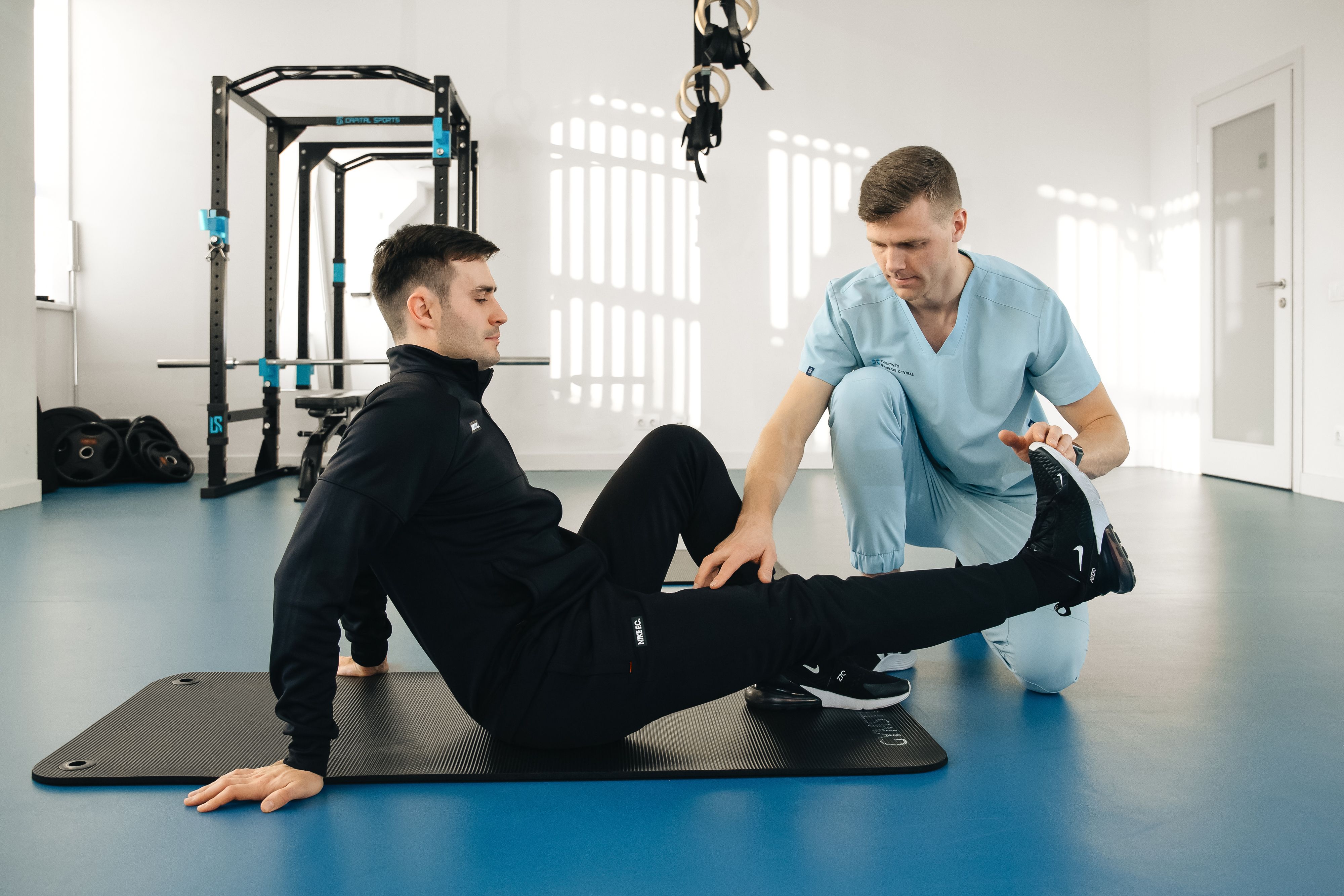 Therapist guiding a client through a mobility stretch